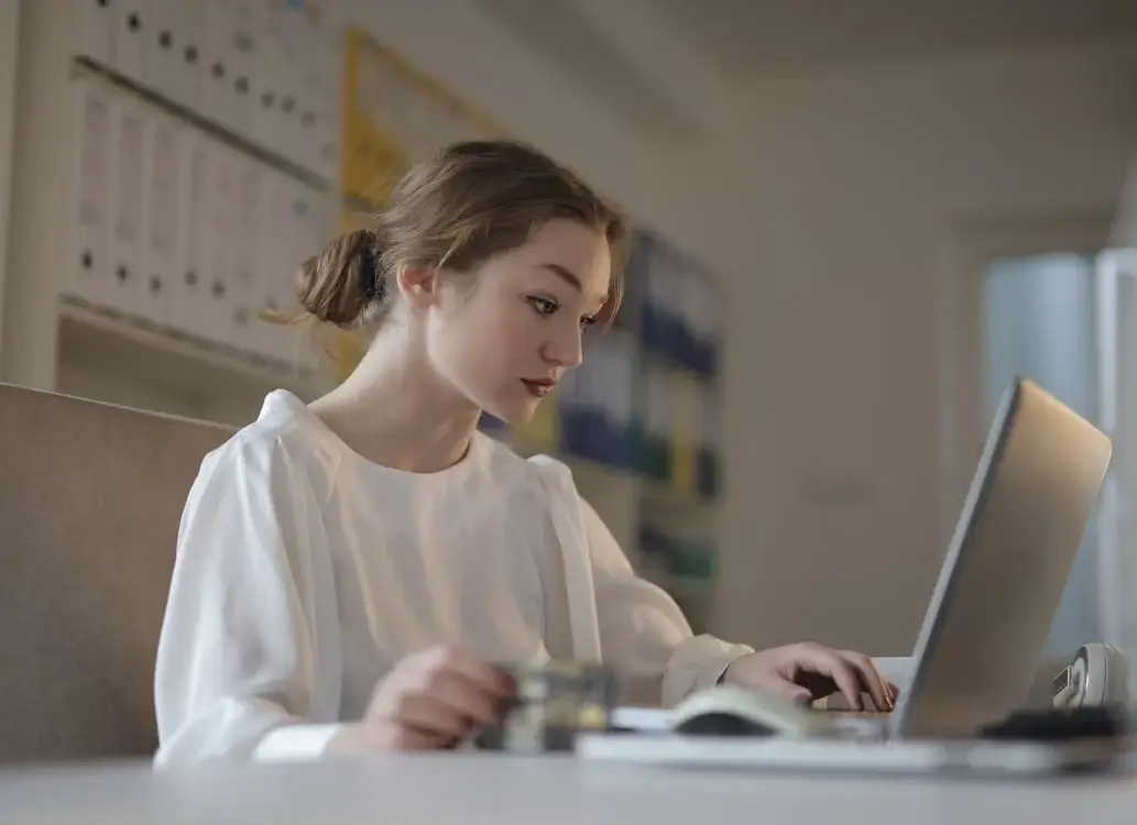 Someone book keeping on a laptop as a side hustle
