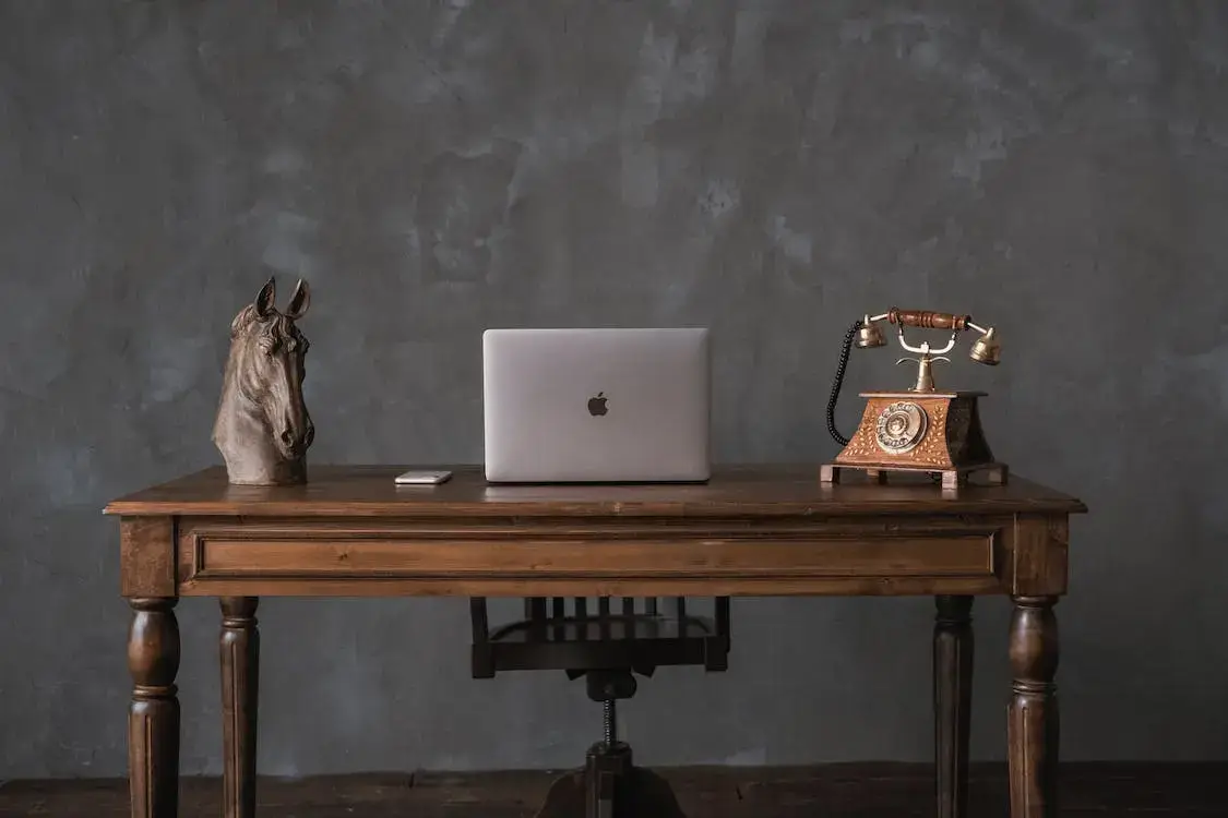 an old fashioned desk with a modern mac on