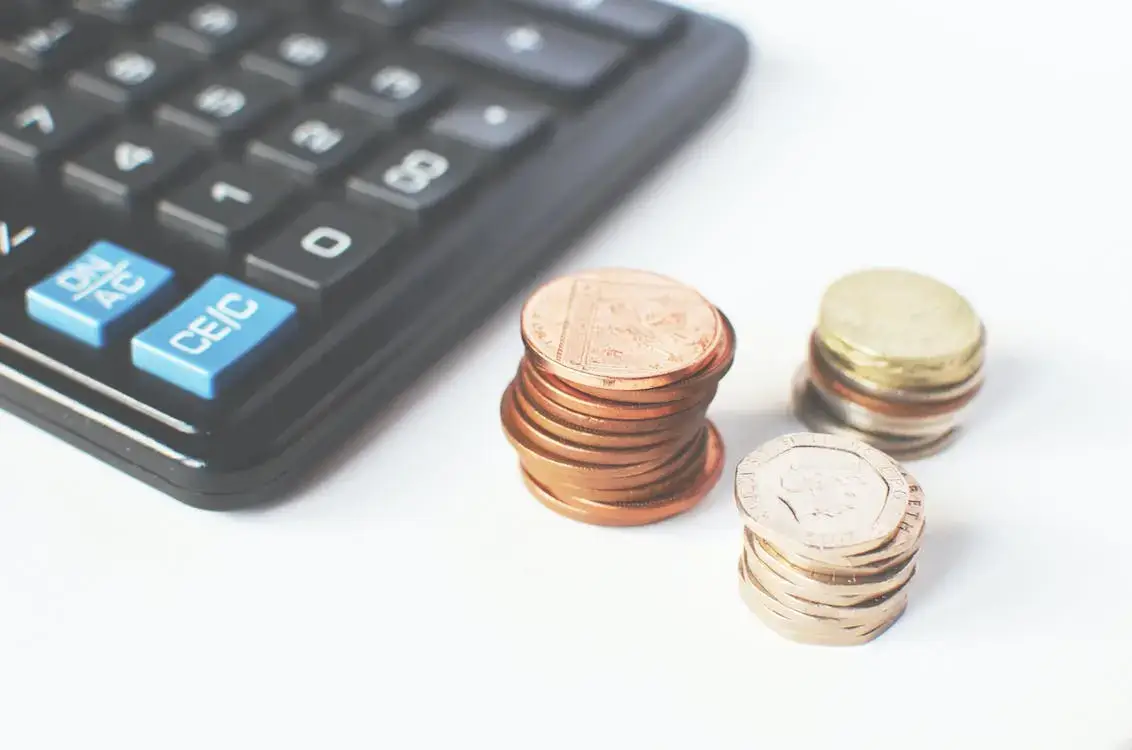 coins piles next to a calculator
